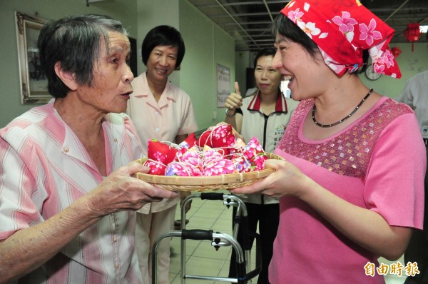 88歲阿嬤劉邱完（左）將親手縫製客家桐花布粽子回贈給市長夫人廖婉如。（記者李忠憲攝）