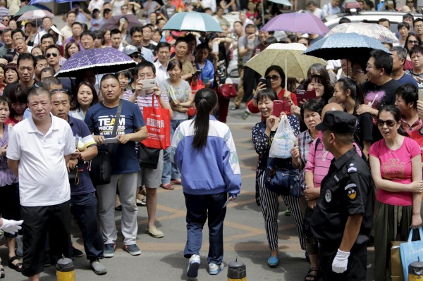 中國高考昨登場，有記者臥底槍手集團，中國教育部震怒揚言嚴懲有關人士，絕不姑息。圖為高考試場外家長聚集情形。（路透）