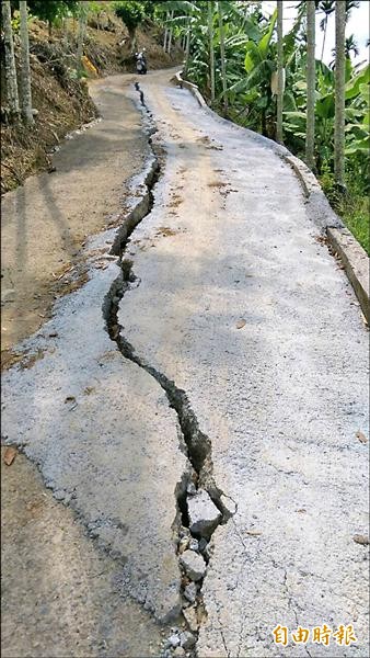 水里鄉玉峰村村里道路因地基掏空嚴重龜裂，裂縫路段幾乎要崩下土坡。（記者劉濱銓攝）