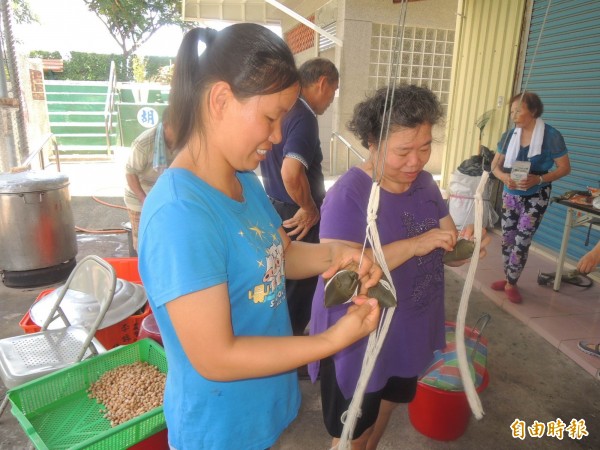 中國籍配偶鄭亞尾（左）跟著社區媽媽們，一起學包粽子技術。（記者林孟婷攝）