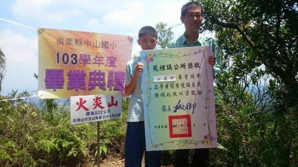 另類畢業體驗，苗栗縣苑裡鎮中山國小學童登火炎山，領畢業證書。（圖由校方提供）