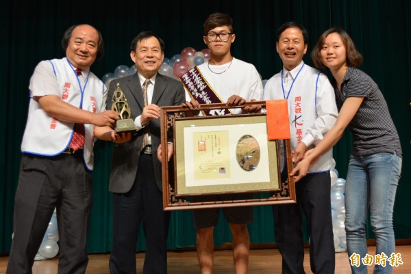 921大地震奇蹟獲救的張景閎（中），勇敢面對生命挑戰，今天由周大觀基金會創辦人周進華（右二）頒發「全球熱愛生命獎章」。（記者陳建志攝）