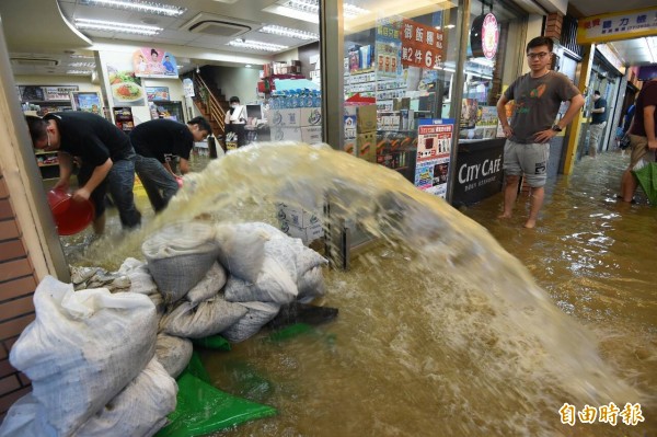 午後雷雨雨勢又快又急，文山區興隆路萬芳醫院附近店家淹水，騎樓與店內全是泥水，店家善待後。（記者廖振輝攝）
