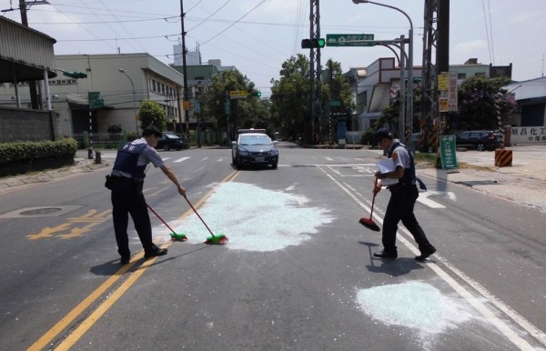 中壢警分局文化派出所員警中壢區北園路、合定路揮汗掃碎玻璃。（記者李容萍翻攝）