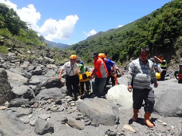 冉姓工人墜落近百米山谷，失去呼吸心跳，消防隊用擔架將他送上救護車。（記者陳祐誠翻攝）