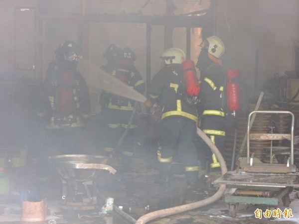 消防人員進入屋內、並持續用水柱降低燃燒溫度。（記者林孟婷攝）