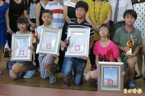 高雄畢業生的市長獎為金色海豚意象造型獎座（右一），議長獎（左一）、局長獎（左二）、區長獎（中）也是同一造型，只是顏色不同。（記者洪定宏攝）