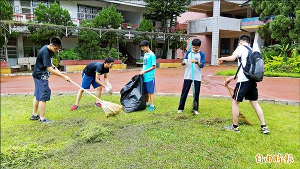 南投市中興國中應屆畢業生為了完成騎單車遊日月潭夢想，到明潭國中除草打工換宿。（記者劉濱銓攝）