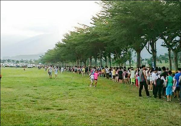 鹿野龍田飛行傘降落場大草皮周遭，等候接駁車的民眾排長龍。（讀者提供）