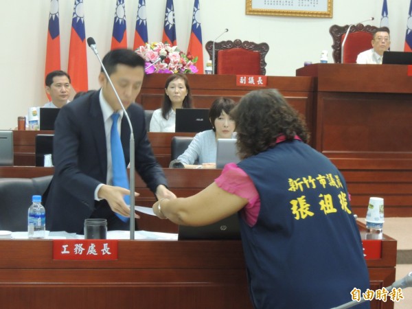 新竹市議會國民黨團十名議員在總質詢時首次拉白布條抗議市府謀殺東區圖書館，發起人張祖琰則把兩千份連署書交給市長林智堅。（記者洪美秀攝）