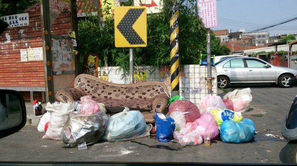 新竹縣湖口鄉民彭小姐投訴，中興公園客運站牌旁空地，長期被人亂丟垃圾，經常看到垃圾袋堆積如山。（記者廖雪茹翻攝）