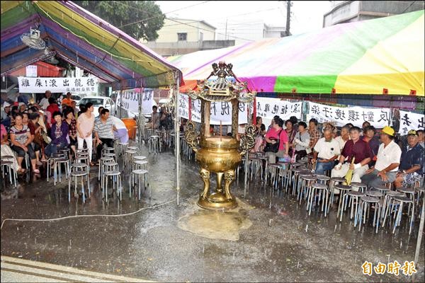 村民冒大雨參加協調會，表達反對養雞場。（記者吳世聰攝）