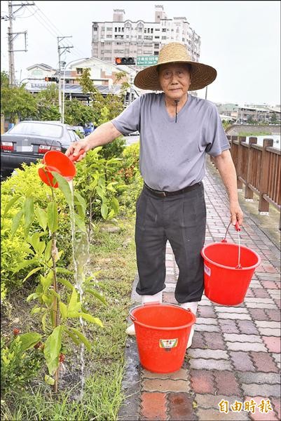 烏日仁德社區的幸福河畔近來缺乏水源灌溉，八十一歲志工楊日仙，每天清晨四點就提水澆花，讓幸福河畔持續維持綠意。（記者陳建志攝）