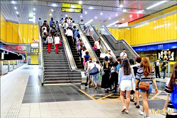 民眾搭乘電扶梯，習慣站在右側，左側讓其他乘客通行。（記者郭逸攝）