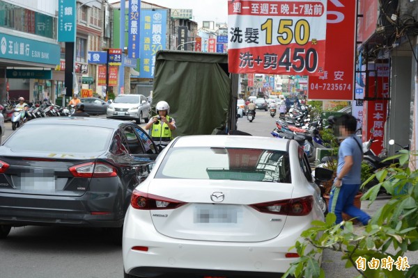 警方在彰化市曉陽路取締汽車路邊併排停車，車主趕緊駛離以免被開單。（記者湯世名攝）