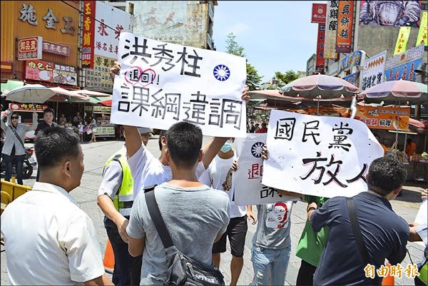 國民黨總統參選人洪秀柱昨到鹿港天后宮參訪，場外民眾持標語高呼「國民黨放人！」（記者湯世名攝）