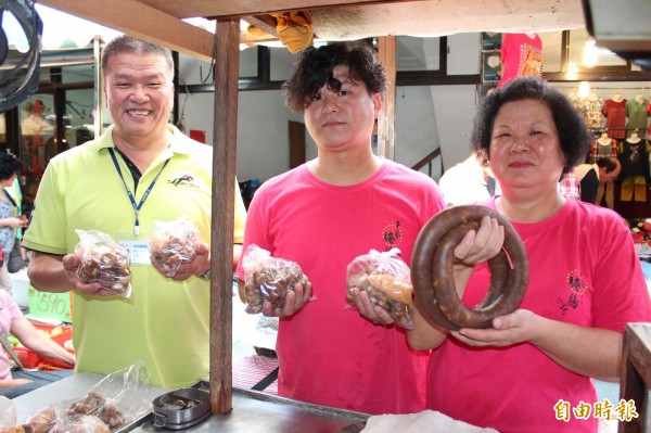 新埔鎮公所秘書黃洸洲（左起依序往右）代表鎮長林保祿推薦市場攤商邱國煦和邱媽媽林鳳嬌手做的「新埔腌腸」真的原汁原味，好吃又安全。（記者黃美珠攝）