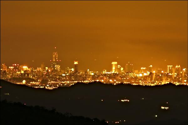 在阿里山上可欣賞到高雄85摩天大樓與夢時代摩天輪的美麗夜景。（張文良提供）