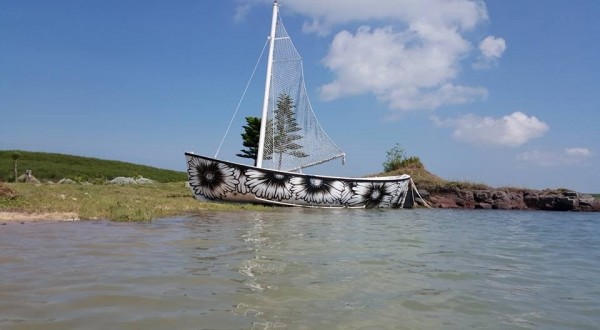 環島塗鴉團隊在澎湖漁船上，塗鴉出天人菊圖案。（候鳥潮間帶民宿提供）