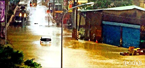 湳仔溪水暴漲，淹沒環河道路，小客車車身泡水動彈不得。（記者陳韋宗攝）