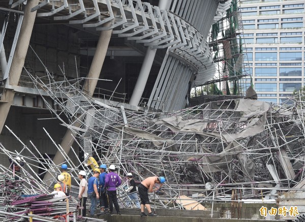 颱風蘇迪勒毀損部分台北市大巨蛋工程鷹架和帷幕，北市府開出罰單，都發局等相關單位代表9日前往現場召開「大巨蛋工地安全會議 」，工人也在現場清理倒塌的鷹架。（記者廖振輝攝）