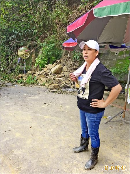 有木里長的太太胡幸姍站在北一一四鄉道路基塌陷處入山的那側，負責對外聯繫、指揮和通報內部狀況。（記者李雅雯攝）