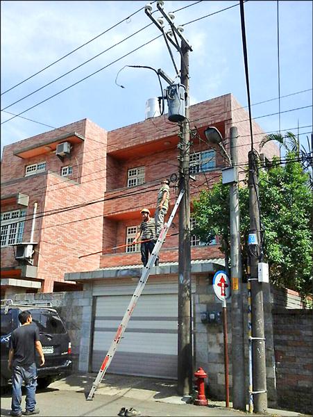 楊梅地區遲遲不來電，民眾乾脆爬上電桿，要自行修理。（市議員周玉琴提供）