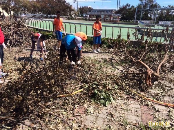 建國國中曾就讀好收國小的學生，今回到母校幫忙整理校園。（記者陳燦坤攝）