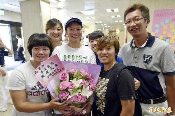 在八仙塵爆中受傷的射箭選手喻婷妍（中捧花者），13日在家人、教練及射箭隊同學的陪伴下出院。（記者叢昌瑾攝）