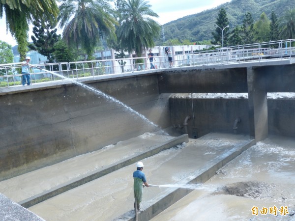 淨水廠所有基層員工皆穿起青蛙裝、徒手撐起水管，日以繼夜清洗沉澱池。（記者蕭婷方攝）