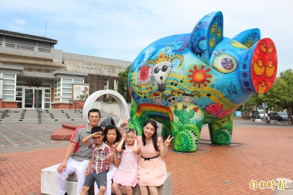 台灣燈會燈王創作者張淑雯（右）融合了義民祭典、新竹縣觀光資源、以及她任教國小的特色，跟家人一起做出身後的「創意花燈神豬」。（記者黃美珠攝）