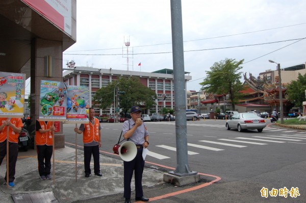 交通新罰則上路，白河分局員警持大聲公、標語大陣仗在路口宣導。（記者王涵平攝）