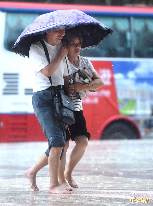 台北地區今日下午下起大雨，明各地仍有午後雷陣雨的可能，提醒民眾出門記得帶傘。（記者方賓照攝）