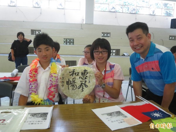 水里國中校長陳啟濃（右）歡迎遠道的日本學生（左），並送上本地學生的書法作品當作紀念。（記者劉濱銓攝）