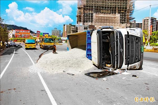 賴姓砂石車駕駛昨行經新北市五股區一處路口，疑似為了搶黃燈而加速左轉，車身抵抗不了離心力翻覆，砂石灑滿馬路。（記者黃捷攝）