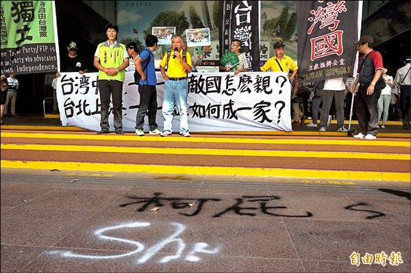 「908台灣國」創辦人王獻極昨前往北市府抗議，並在市府門口噴下「柯屁」等字眼。（記者涂鉅旻攝）