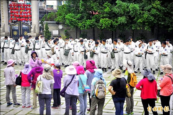 國軍全副武裝灑藥，但警員、衛生局人員卻沒有防護衣可穿，令部分警員自嘆命不如人，但衛生局說，有機藥劑不會傷害哺乳類。（記者王捷攝）