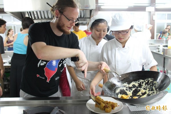 南市光華高中餐旅群學生引導美國大學生烹調台灣美食。（記者王俊忠攝）