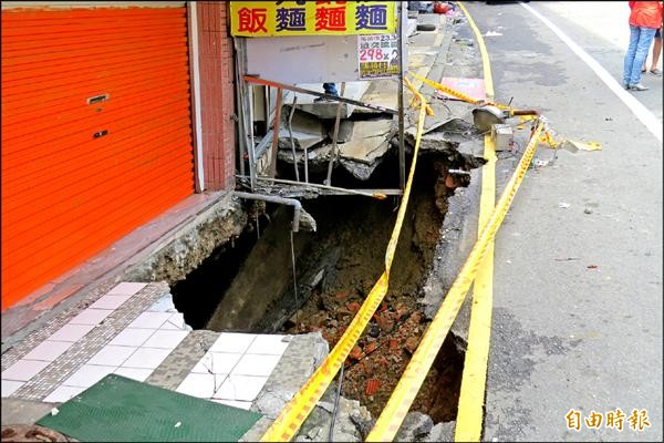 25日凌晨大雨，基隆市復興路179之4號門口的坍塌破洞變成2x4公尺、深7公尺的大窟窿。（記者俞肇福攝）