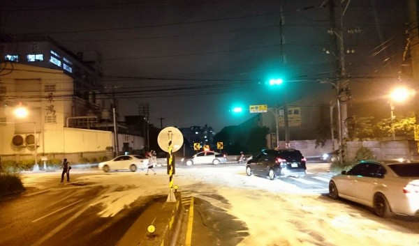 文化派出所員警在中壢區桃圳路與北園路口撒上木屑，細沙避免車輛打滑。（記者李容萍翻攝）