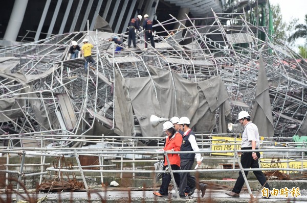 大巨蛋工程因蘇迪勒風災受損，更有屋頂建材被吹到馬路上，嚴重影響民眾安全，北市府當時對此事開出罰單，都發局長林洲民（橘衣者）於風災後也到場親自視察。（資料照，記者廖振輝攝）