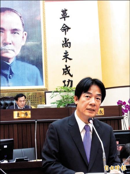台南市長賴清德昨進議會報告，議長李全教坐在主席台，議事大廳上的「革命尚未成功」精神標語，格外耐人尋味。（記者洪瑞琴攝）