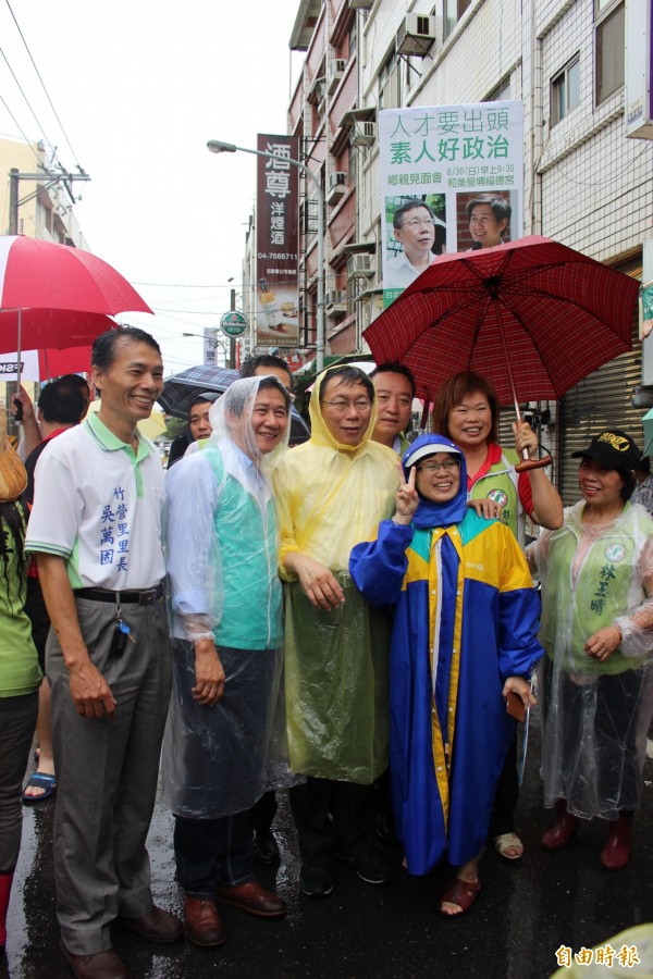 台北市長柯文哲（左3）穿輕便雨衣頂著濛濛細雨，陪同民進黨立委參選人陳文彬（左2）到彰化縣和美鎮營埔福德宮跟居民互動。（記者張聰秋攝）