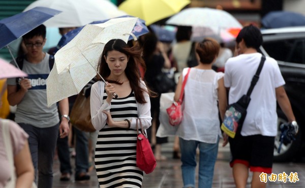 明天降雨漸緩，但各地仍有降雨機會，民眾應攜帶雨具以備不時之需。白天高溫也會稍微回暖一些。（資料照，記者林正堃攝）