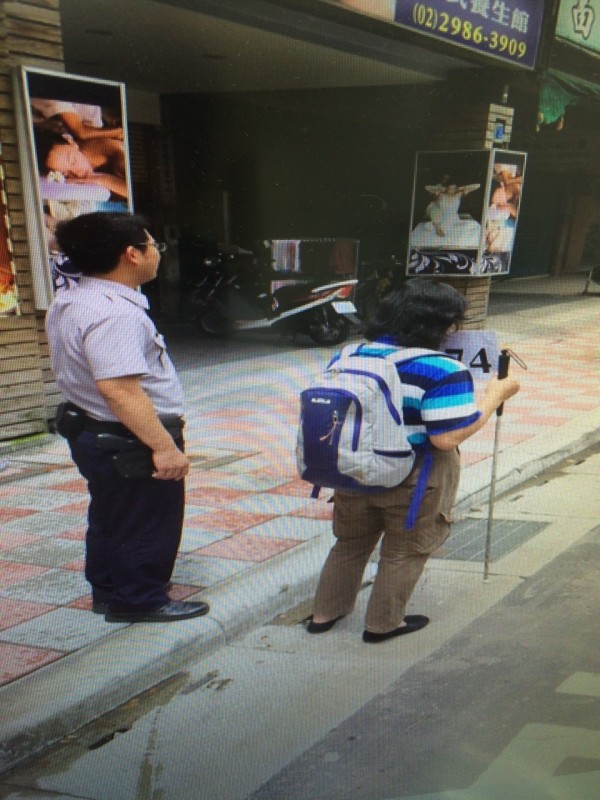 巡邏警員熱心地陪伴盲婦等公車。（記者曾健銘翻攝）