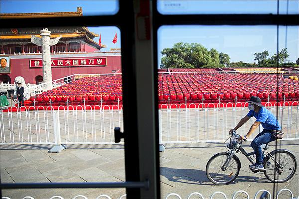 中國今天舉行紀念抗戰勝利七十週年大閱兵，國民黨前主席連戰等台灣「閱兵團」也將參加。北京全城昨天戒備，維安提升至最高等級。圖為一名民眾騎腳踏車經過已戒備的天安門廣場閱兵觀禮區。（路透）