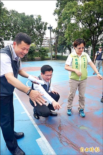 市長林佳龍（中）視察石牌公園籃球場鋪面龜裂情形。（記者歐素美攝）