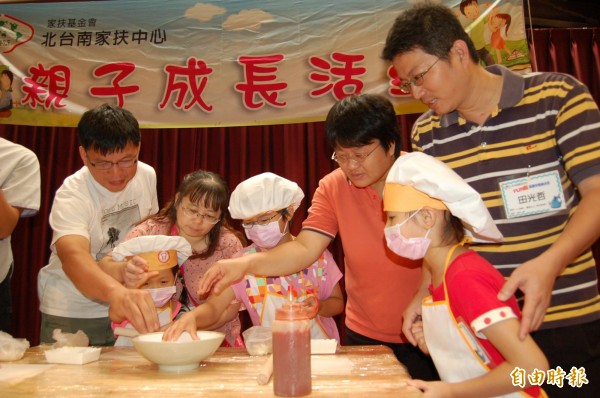 北台南家扶中心寄養家庭親子學作披薩，謝文貴、張翠津（左）與田光哲、施雅仁（右）夫婦細心教導寄養童。（記者王涵平攝）