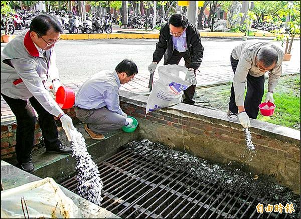 大專院校開學在即，南臺科大將鹽撒放在排水溝中，避免孳生病媒蚊。（記者林孟婷攝）