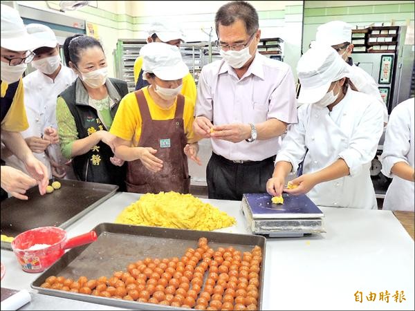 勞工局長王鑫基（右二）也加入協助行列，幫忙製作中秋節月餅。（記者林孟婷攝）